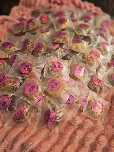 Large pile of individually wrapped cookies on a soft pink background