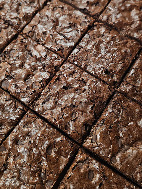 Close up of sliced fudge brownies with crackle skin and chocolate chips