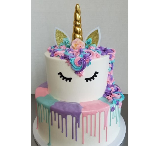 Two tiered unicorn cake decoated in pink, purple and teal.