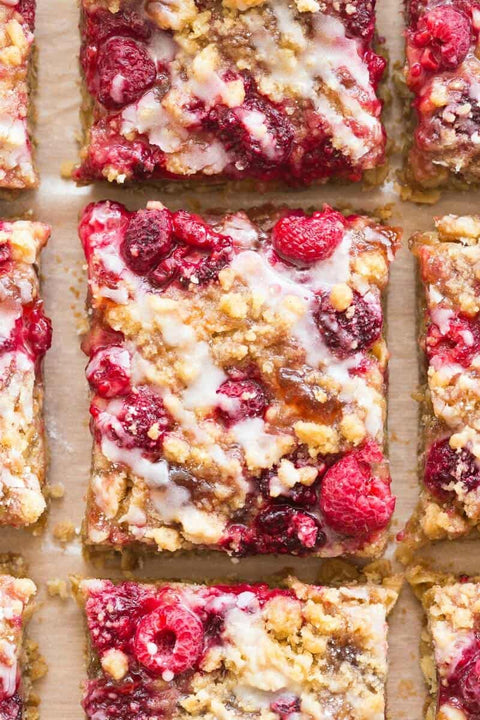 Close up of raspberry lemon crumble bars, drizzled with white chocolate.